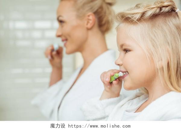 幸福的母亲和女儿在一起刷牙